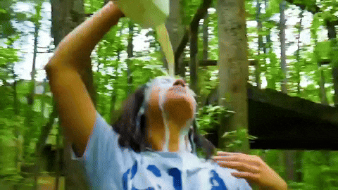 Woman pouring milk with vitamin A on her skin while in nature