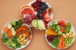 Top view of vibrant plates of fresh fruits and vegetables, perfect for a healthy lifestyle.