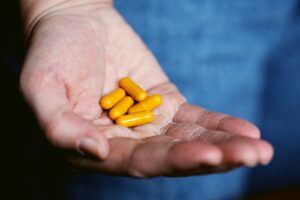 orange vitamin A capsules on persons hand